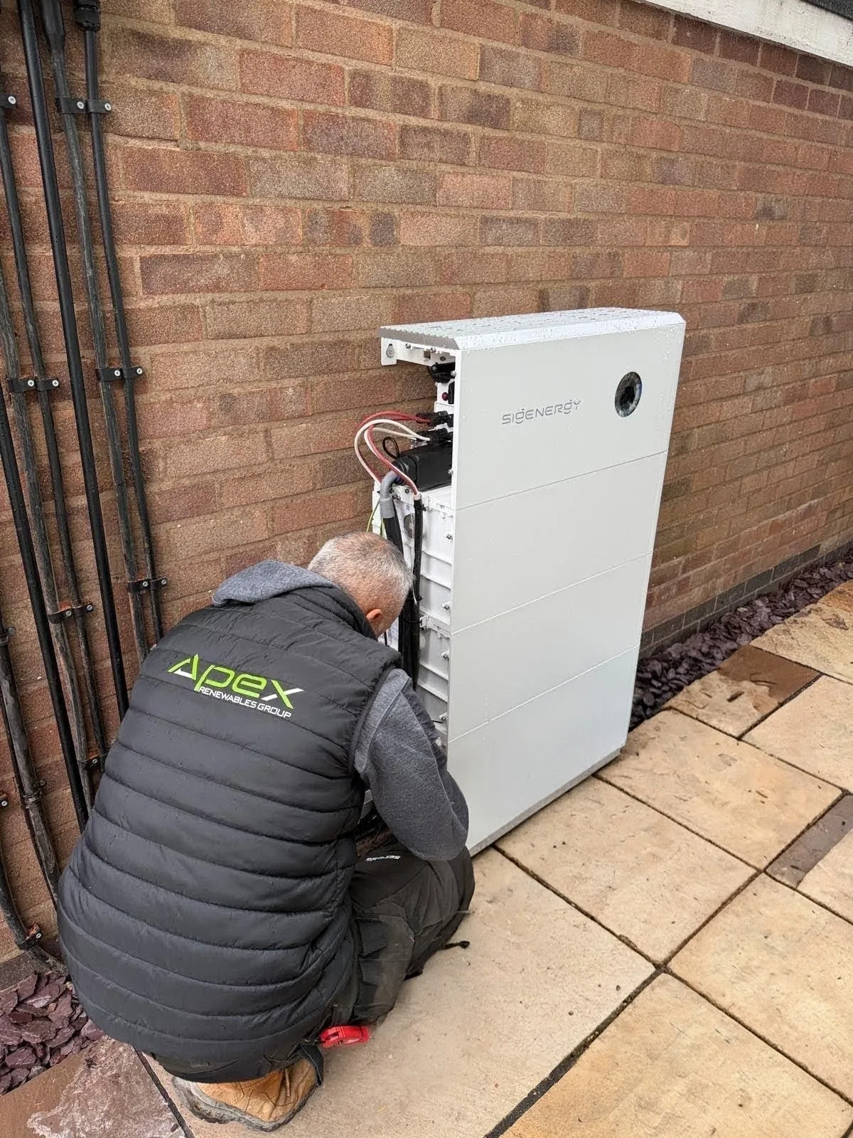 An Apex installer fitting a Sigenergy home battery